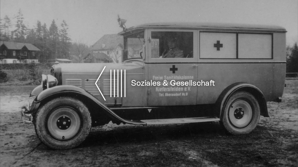 Header: historic Red Cross ambulance with driver in black and white