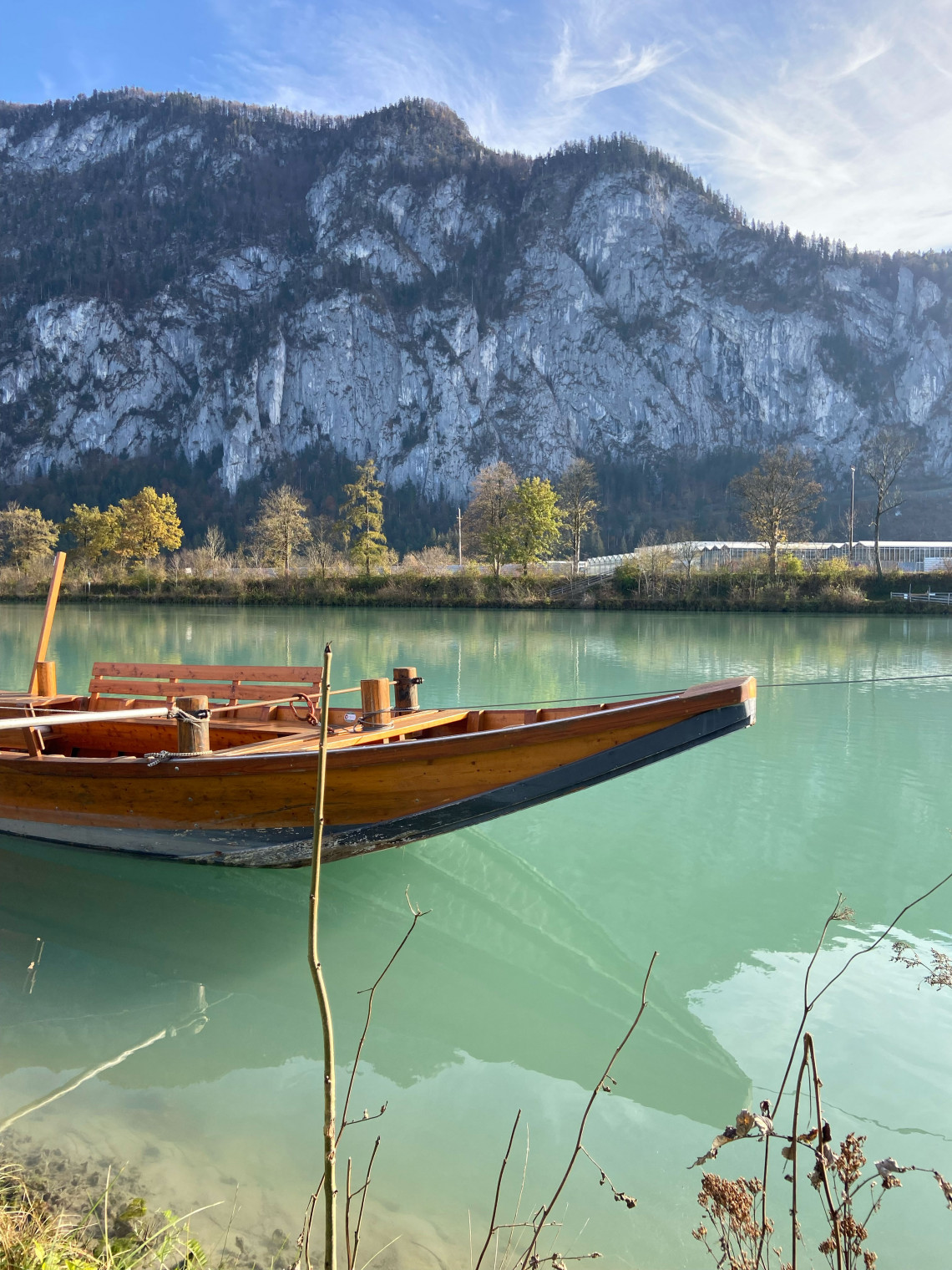 Boat in front of the border mountains on the emerald green Inn