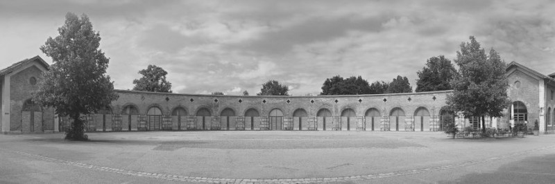 Schwarz-weiß Totale des halbrunden, historischen Backsteinbaus Lokschuppen mit Innenhof in Rosenheim